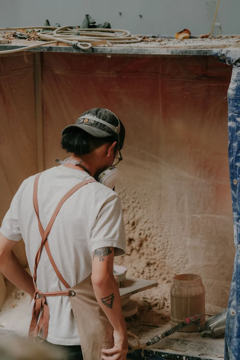 An artisan shaping ceramic pieces in a workshop